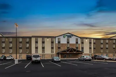 a large building with cars parked in a parking lot at WoodSpring Suites Harrisburg Linglestown in Harrisburg