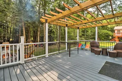 a wooden deck with a pergola and chairs at Game Room and Yard Family Paradise in Pocono Summit in Pocono Summit Estates