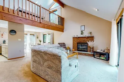 a living room with a couch and a fireplace at House in the Woods in Albrightsville