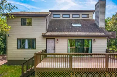 a house with a wooden fence in front of it at House in the Woods in Albrightsville