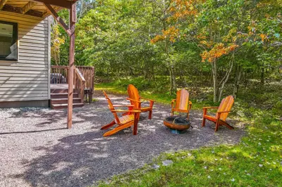 a group of chairs sitting outside of a house at House in the Woods in Albrightsville