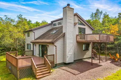 a home with a large deck and a house at House in the Woods in Albrightsville