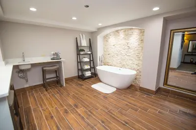 a bathroom with a white tub and a wooden floor at Best Western Plus Fairfield Executive Inn in Fairfield