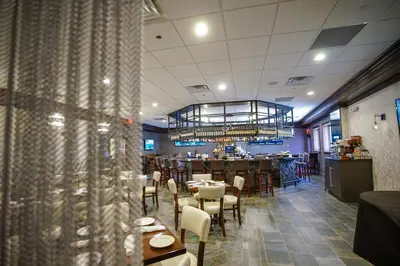 a restaurant with tables and chairs and a chandelier at Best Western Plus Fairfield Executive Inn in Fairfield