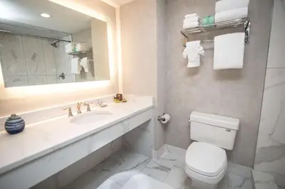 a bathroom with a toilet and a sink and a mirror at Best Western Plus Fairfield Executive Inn in Fairfield