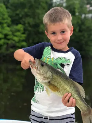 a young boy holding a fish in his hand at Lakewood Park Campground - Luxury Cabin in Barnesville