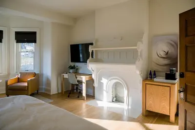 a bedroom with a fireplace and a desk and a bed at Wilbur Mansion in Bethlehem