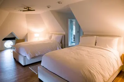 a bedroom with two beds with white sheets at Wilbur Mansion in Bethlehem