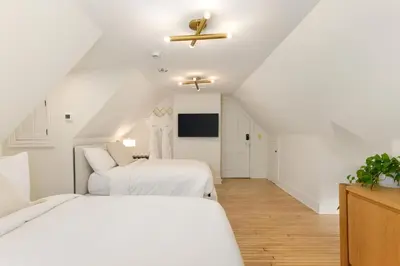 a white bedroom with two beds and a ceiling at Wilbur Mansion in Bethlehem