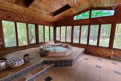 a large room with a hot tub in a room with windows at Large Vacation Home Villa- Pool, Indoor Hotub, Game Room, up to 25 guests in Monticello