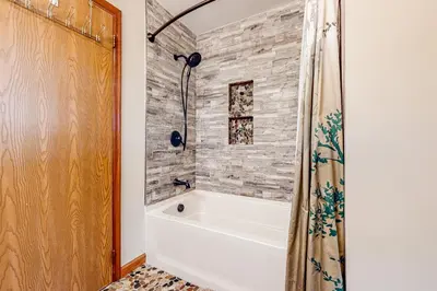 a white bath tub in a bathroom with a brick wall at The Cabin in Pocono Summit