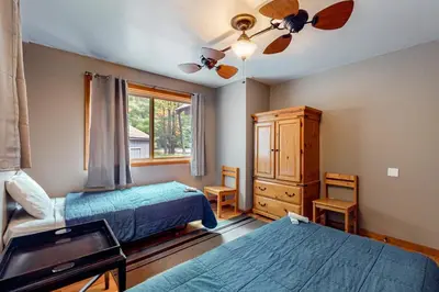 a bedroom with two beds and a dresser and a window at The Cabin in Pocono Summit