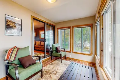 a living room with a couch and chairs and windows at The Cabin in Pocono Summit