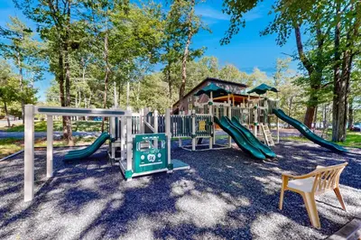 a playground with a slide and a play structure at The Cabin in Pocono Summit