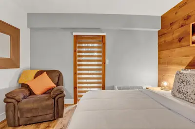a bedroom with a large bed and a brown chair at Chimney Hill Estate Inn in Lambertville