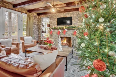 a living room with a christmas tree and a fireplace at Chimney Hill Estate Inn in Lambertville