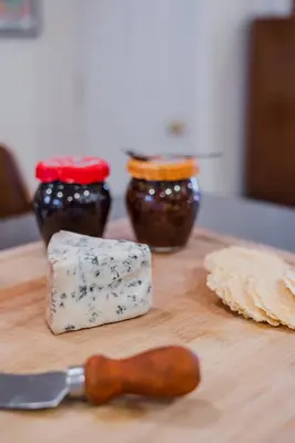 a wooden cutting board with cheese and a knife at Bedroom in thoughtfully decorated East Passyunk home (South Philadelphia) in Philadelphia