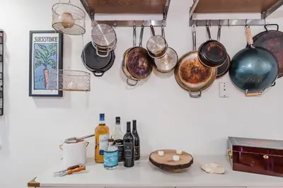 a bunch of pots and pans hanging on a wall at Bedroom in thoughtfully decorated East Passyunk home (South Philadelphia) in Philadelphia