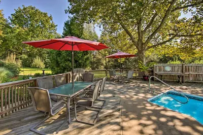 a patio with a table and umbrella and a pool at Amish Country Apartment with Cozy Fireplace! in New Holland