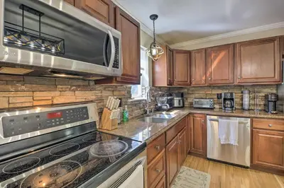 a kitchen with wooden cabinets and stainless steel appliances at Hot Tub, Fire Pit and Lake Access Poconos Escape! in Albrightsville