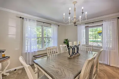 a dining room with a table and chairs and windows at Hot Tub, Fire Pit and Lake Access Poconos Escape! in Albrightsville