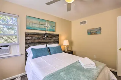 a bedroom with a bed with blue pillows and a window at Hot Tub, Fire Pit and Lake Access Poconos Escape! in Albrightsville
