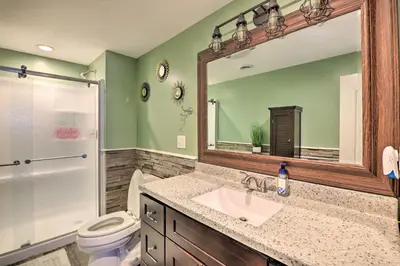 a bathroom with a sink and a toilet and a mirror at Hot Tub, Fire Pit and Lake Access Poconos Escape! in Albrightsville