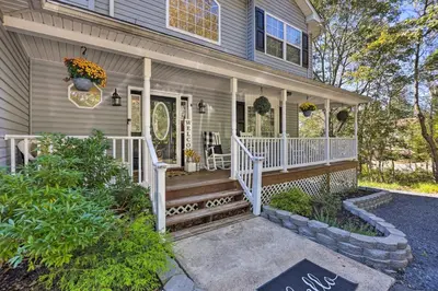 a home with a white porch and stairs to the front door at Hot Tub, Fire Pit and Lake Access Poconos Escape! in Albrightsville