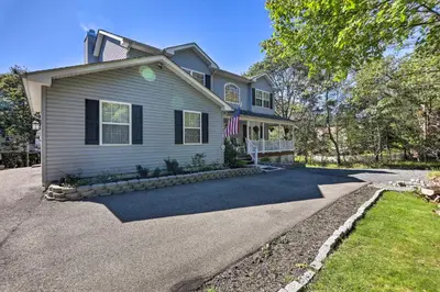 a house with a flag in the driveway at Hot Tub, Fire Pit and Lake Access Poconos Escape! in Albrightsville
