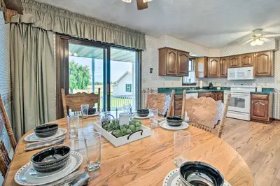 a kitchen and dining room with a wooden table at Charming Lewisburg Home with Hot Tub and Games! in Lewisburg
