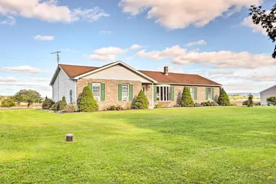 a house with a large yard with green grass at Charming Lewisburg Home with Hot Tub and Games! in Lewisburg