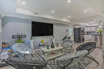 a living room with three chairs and a table and a tv at Stunning South Fallsburg Home with Pool and Deck! in South Fallsburg