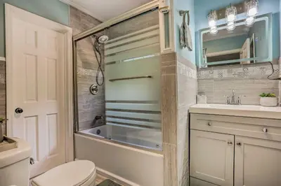 a bathroom with a tub and a toilet and a sink at Stunning South Fallsburg Home with Pool and Deck! in South Fallsburg