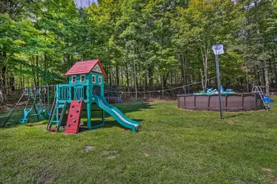 a playground with a slide in the grass at Stunning South Fallsburg Home with Pool and Deck! in South Fallsburg