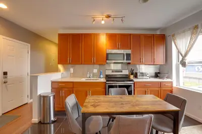a kitchen with wooden cabinets and a table with chairs at Philadelphia Apartment, Near Transit and Sites! in Philadelphia