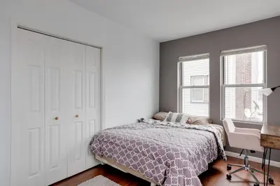 a bedroom with a bed and a desk and windows at Philadelphia Apartment, Near Transit and Sites! in Philadelphia
