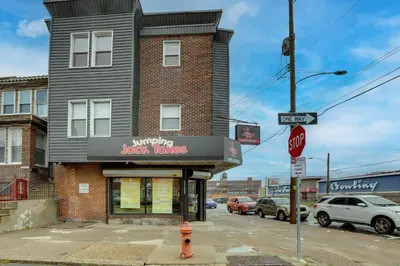 a building on the corner of a street with a stop sign at Philadelphia Apartment, Near Transit and Sites! in Philadelphia