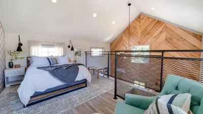 a bedroom with a bed and a staircase at A newly built Tiny House in the center of Historic Kennett Square in Kennett Square