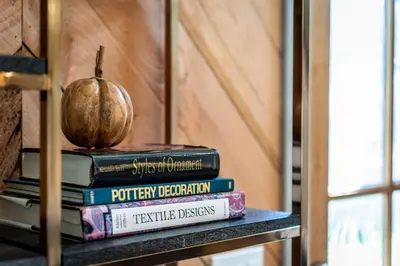 a stack of books on a table with an apple on top at A newly built Tiny House in the center of Historic Kennett Square in Kennett Square