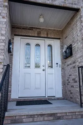 a white front door of a brick house at Urban Oasis Spacious 3BR 2BA Patio Near NYC EWR American Dream Mall in Newark