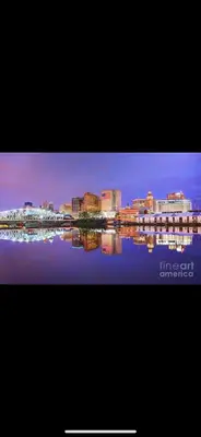 a view of a city with a reflection in the water at Urban Oasis Spacious 3BR 2BA Patio Near NYC EWR American Dream Mall in Newark