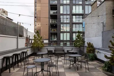 a patio with tables and chairs on a building at Kasa Lantern Lower East Side in New York