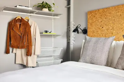 a bedroom with a bed with a jacket and shelves at Kasa Lantern Lower East Side in New York