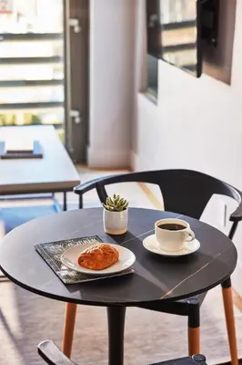 a table with a plate of food and a cup of coffee at Kasa Lantern Lower East Side in New York