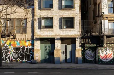 a brick building with graffiti on the side of it at Kasa Lantern Lower East Side in New York