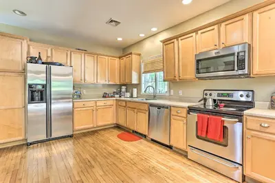 a kitchen with wooden cabinets and stainless steel appliances at Pet-Friendly Grand Pine Bush Retreat on 2 Acres! in Pine Bush