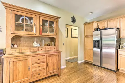 a kitchen with wooden cabinets and a stainless steel refrigerator at Pet-Friendly Grand Pine Bush Retreat on 2 Acres! in Pine Bush
