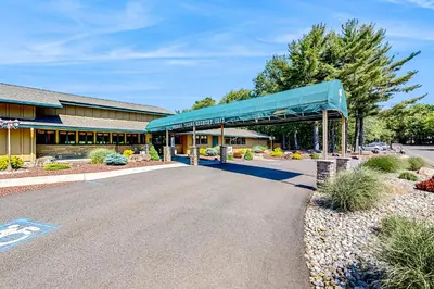 a building with a blue awning next to a road at Tree and Easy in Tobyhanna