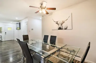 a dining room with a glass table and a ceiling fan at 12 Mi to Camelback Ski Resort Home with Decks! in Tobyhanna