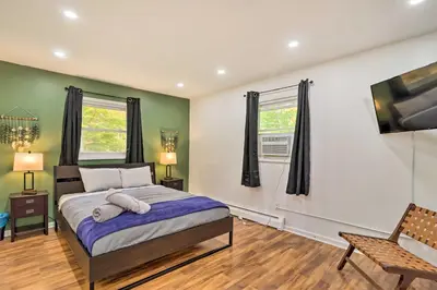 a bedroom with a bed and a flat screen tv at 12 Mi to Camelback Ski Resort Home with Decks! in Tobyhanna